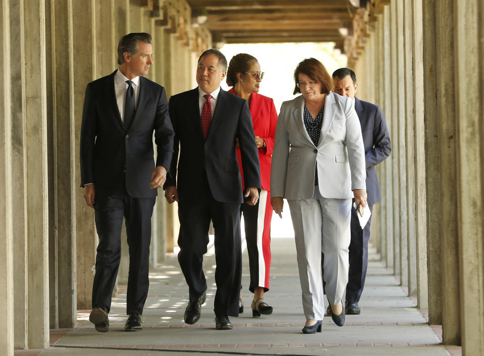 California Gov. Gavin Newsom, left, along with Assembly Budget Chairman Phil Ting, D-San Francisco, second left, Senate Budget Chairwoman Holly Mitchell, D-Los Angeles, third from left, State Senate President Pro Tem Toni Atkins, of San Diego, third from left, and Assembly Speaker Anthony Rendon, of Lakewood, background right, walk through the campus of Sacramento City College, In Sacramento, Calif., Monday, July 1, 2019. During his visit to the school Newsom signed several state budget trailer bills then told an assembled crowd that that he vowed to continue expanding taxpayer-funded health benefits to people living in the country illegally .(AP Photo/Rich Pedroncelli)