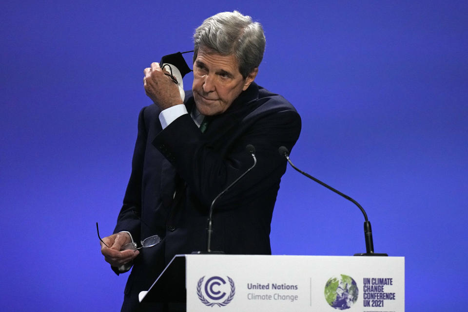 John Kerry, United States Special Presidential Envoy for Climate takes off his mask as he arrives to speak at a press conference at the COP26 U.N. Climate Summit in Glasgow, Scotland, Friday, Nov. 5, 2021. The U.N. climate summit in Glasgow gathers leaders from around the world, in Scotland's biggest city, to lay out their vision for addressing the common challenge of global warming. (AP Photo/Alastair Grant)