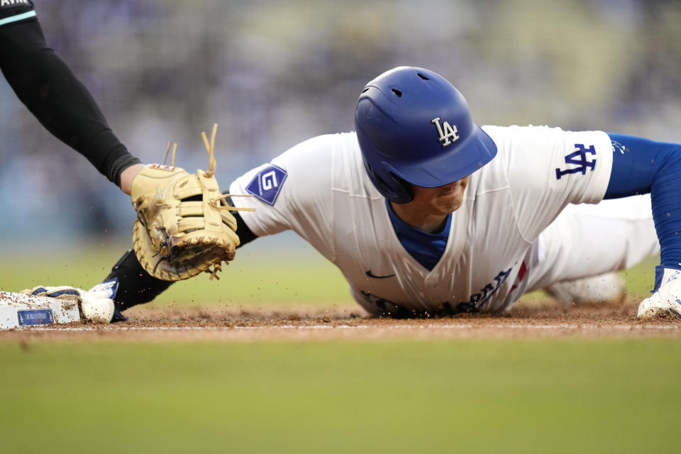 Los Angeles Dodgers' Shohei Ohtani, right, dives back to first under the tag of Arizona Diamondbacks first baseman Christian Walker during the first inning of a baseball game Wednesday, May 22, 2024, in Los Angeles. (AP Photo/Mark J. Terrill)