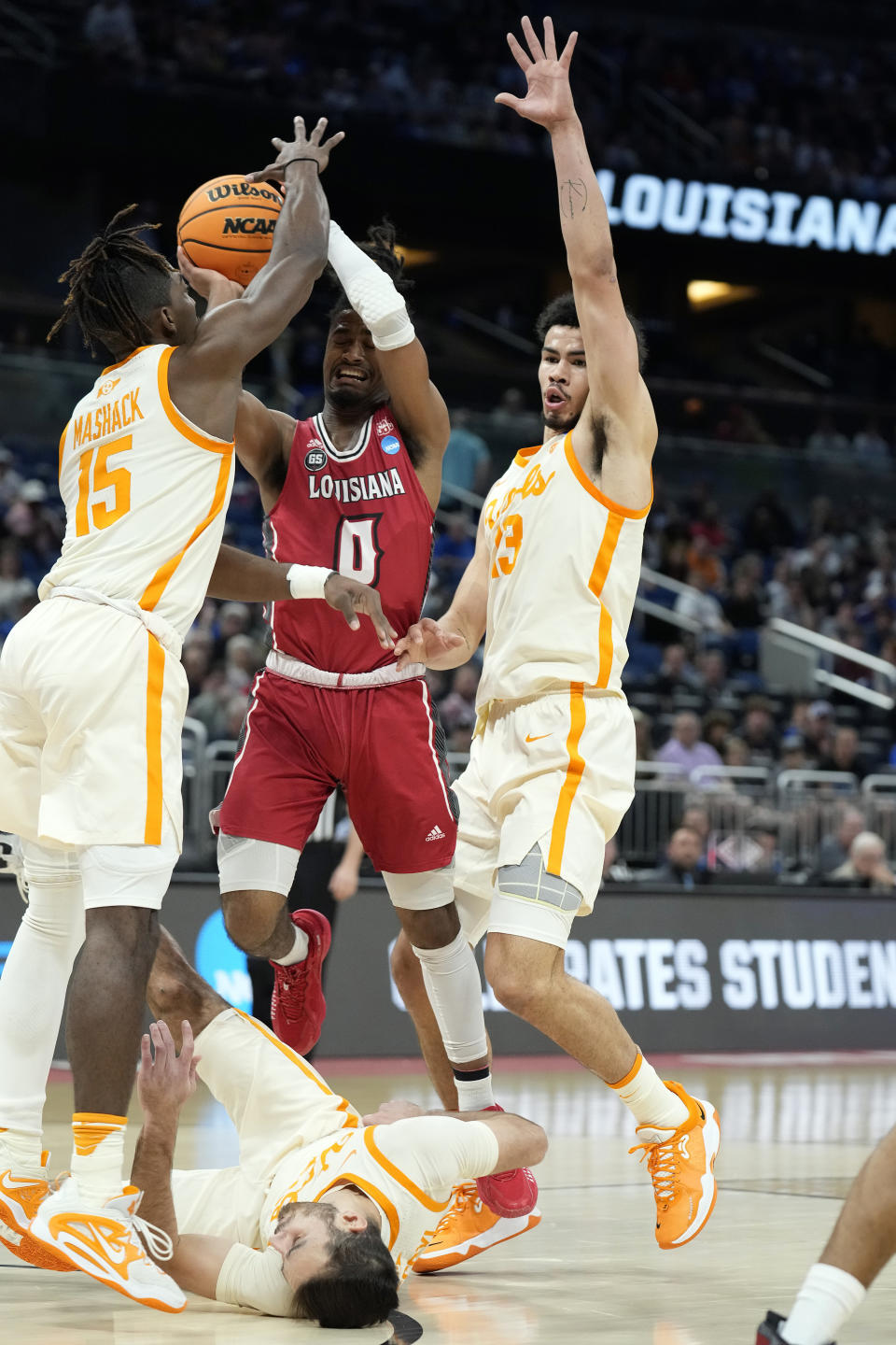 Louisiana guard Themus Fulks (0) shoots against Tennessee guard Jahmai Mashack (15), forward Olivier Nkamhoua (13) and guard Santiago Vescovi, bottom, during the first half of a first-round college basketball game in the NCAA Tournament Thursday, March 16, 2023, in Orlando, Fla. (AP Photo/Chris O'Meara)