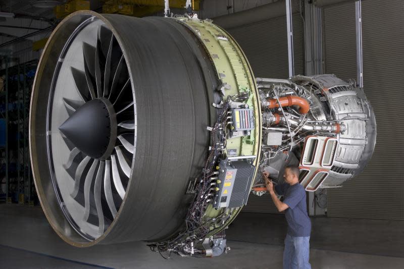 A man works on a GE aircraft turbine.