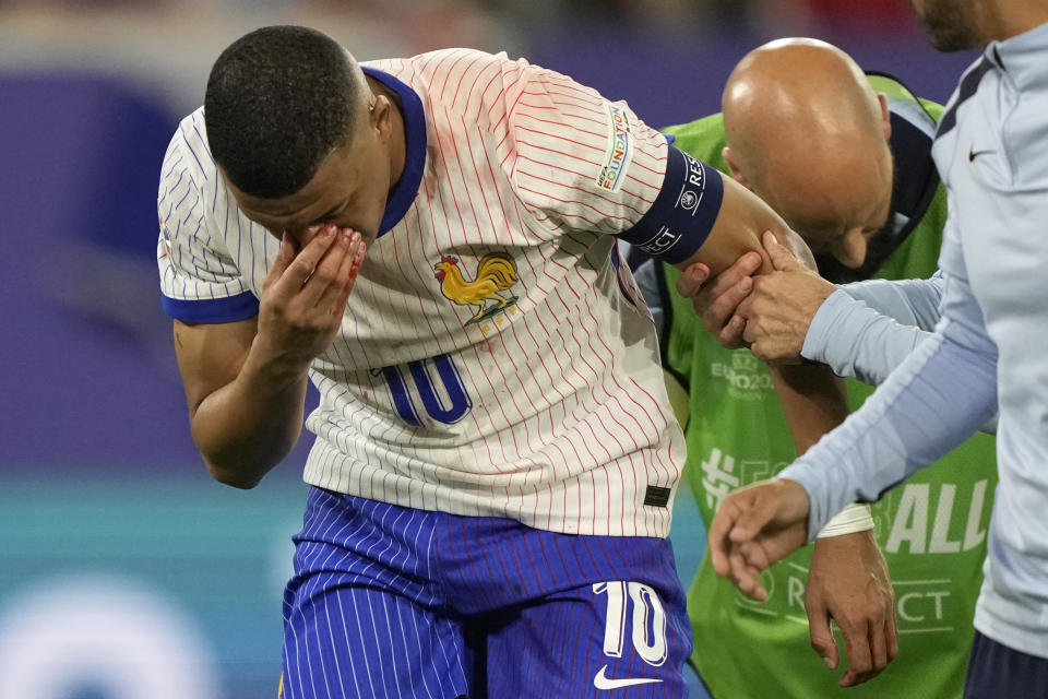 Kylian Mbappe of France holds his nose after suffering an injury during a Group D match between Austria and France at the Euro 2024 soccer tournament in Duesseldorf, Germany, Monday, June 17, 2024. (AP Photo/Martin Meissner)