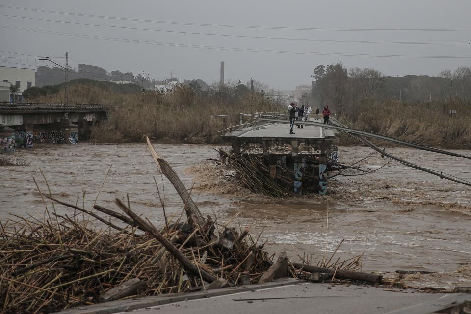 People take snapshots atop of a collapsed bridge in Malgrat, near Barcelona, Spain, Wednesday, Jan. 22, 2020. Since Sunday the storm has hit mostly eastern areas of Spain with hail, heavy snow and high winds, while huge waves smashed into towns on the Mediterranean coast and nearby islands of Mallorca and Menorca. (AP Photo/Joan Mateu)