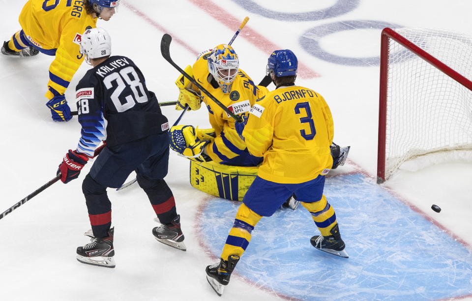 Sweden goalie Hugo Alnefelt (30) looks back at the puck on a goal as United States' Arthur Kaliyev (28) and Tobias Bjornfot (3) wait for a possible rebound during the second period of an IIHF World Junior Hockey Championship game Thursday, Dec. 31, 2020, in Edmonton, Alberta. (Jason Franson/The Canadian Press via AP)