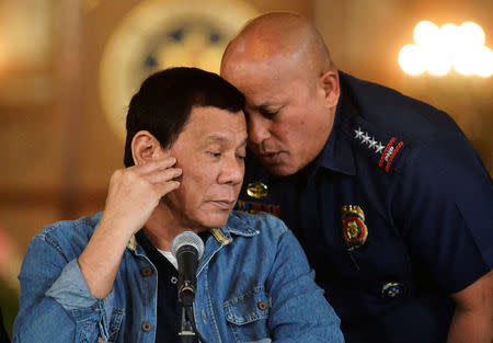 FILE PHOTO: Philippine National Police chief General Ronald Dela Rosa whispers to President Rodrigo Duterte during the announcement of the disbandment of police operations against illegal drugs at the Malacanang palace in Manila, Philippines January 29, 2017. REUTERS/Ezra Acayan/File Photo