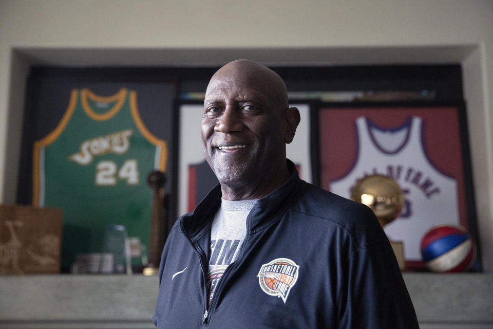 FILE - Spencer Haywood poses in front of his basketball memorabilia at his Las Vegas home Monday, Nov. 29, 2021. With rare exceptions, the best high school basketball players for decades went on to play in college. Then came Spencer Haywood, whose fight with the NBA set the stage for the one-and-done era in college hoops. (AP Photo/Ellen Schmidt, File)