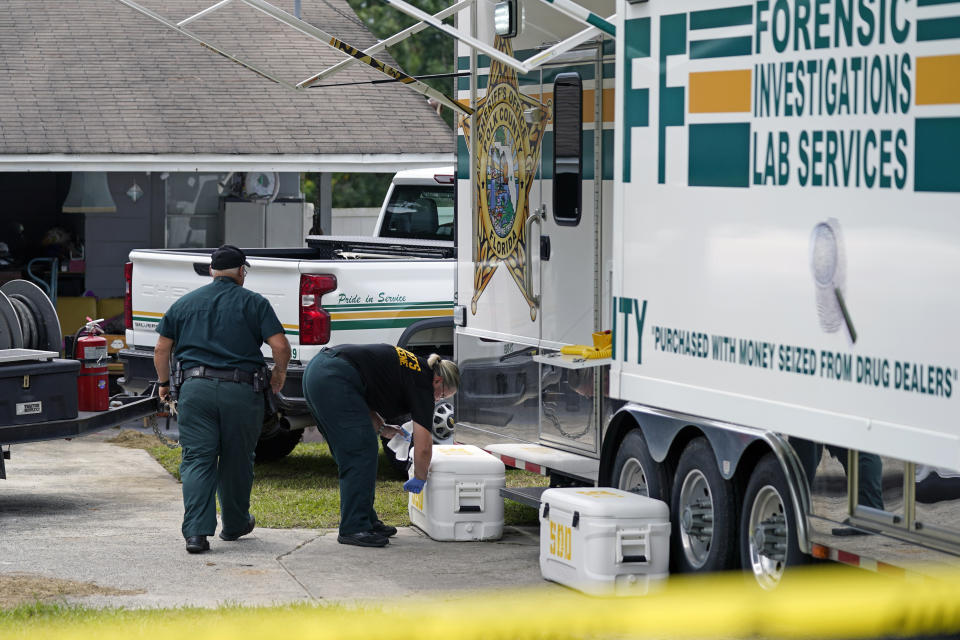 FILE - In this Sept. 7, 2021 file photo, officers from the Polk County Sheriff Department work outside the scene of a shooting in Lakeland, Fla. A grand jury has formally charged Riley in a 22-count indictment that includes four first-degree murder counts in the fatal shooting of a family authorities say he attacked at random. Court documents show the indictment was filed Tuesday, Sept. 21, 2021 in Polk County Circuit Court against Riley. (AP Photo/John Raoux)