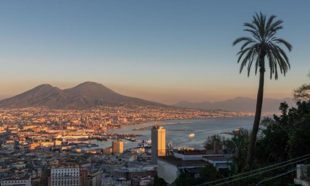 Panoramic view of Naples with Vesuvius towering behind.