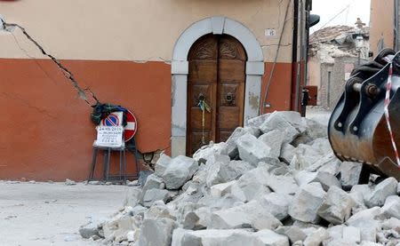 The door of a damaged house is seen behind rubble following an earthquake in Amatrice, central Italy, August 26, 2016. REUTERS/Ciro De Luca