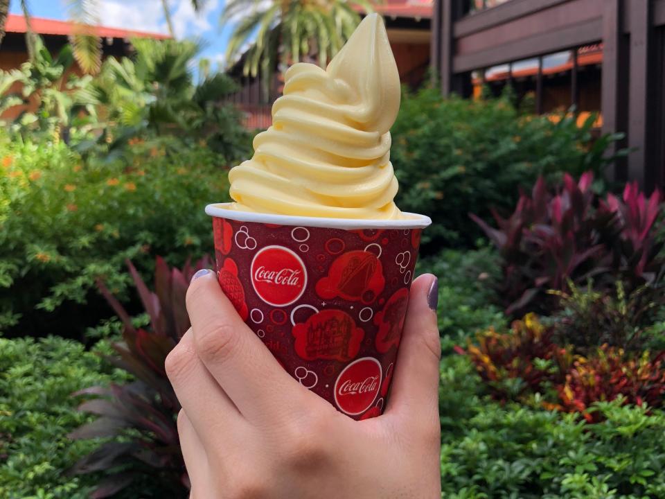 hand holding cup of dole whip at disney polynesian resort