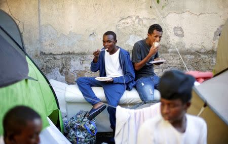 Migrants eat after getting food from volunteers at a makeshift camp in Via Cupa (Gloomy Street) in downtown Rome, Italy, August 1, 2016. REUTERS/Max Rossi/File Photo TPX IMAGES OF THE DAY