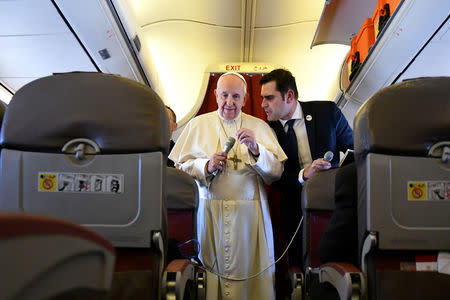 Pope Francis listens to interim director of Holy See Press Office, Alessandro Gisotti as he addresses reporters aboard the plane bringing him back following a two-day trip to Morocco March 31, 2019. Alberto Pizzoli/Pool via REUTERS