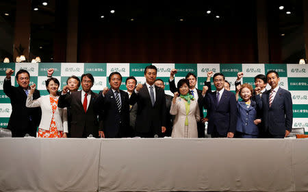 Tokyo Governor Yuriko Koike (7th R), the leader of her new Party of Hope, poses with her party members, include in Goshi Hosono (7th L), a former environment minister and Masaru Wakasa (5th R), a former prosecutor who left the ruling Liberal Democratic Party, during a news conference to announce the party's campaign platform in Tokyo, Japan, September 27, 2017. REUTERS/Issei Kato