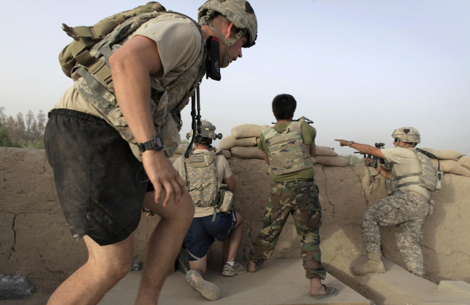 <p>Afghan troops and soldiers with the US Army’s 1-320 Field Artillery Regiment, 101st Airborne Division take up fighting positions after taking incoming fire at Combat Outpost Nolen in the Arghandab Valley north of Kandahar, on July 27, 2010. (Photo: Bob Strong/Reuters) </p>