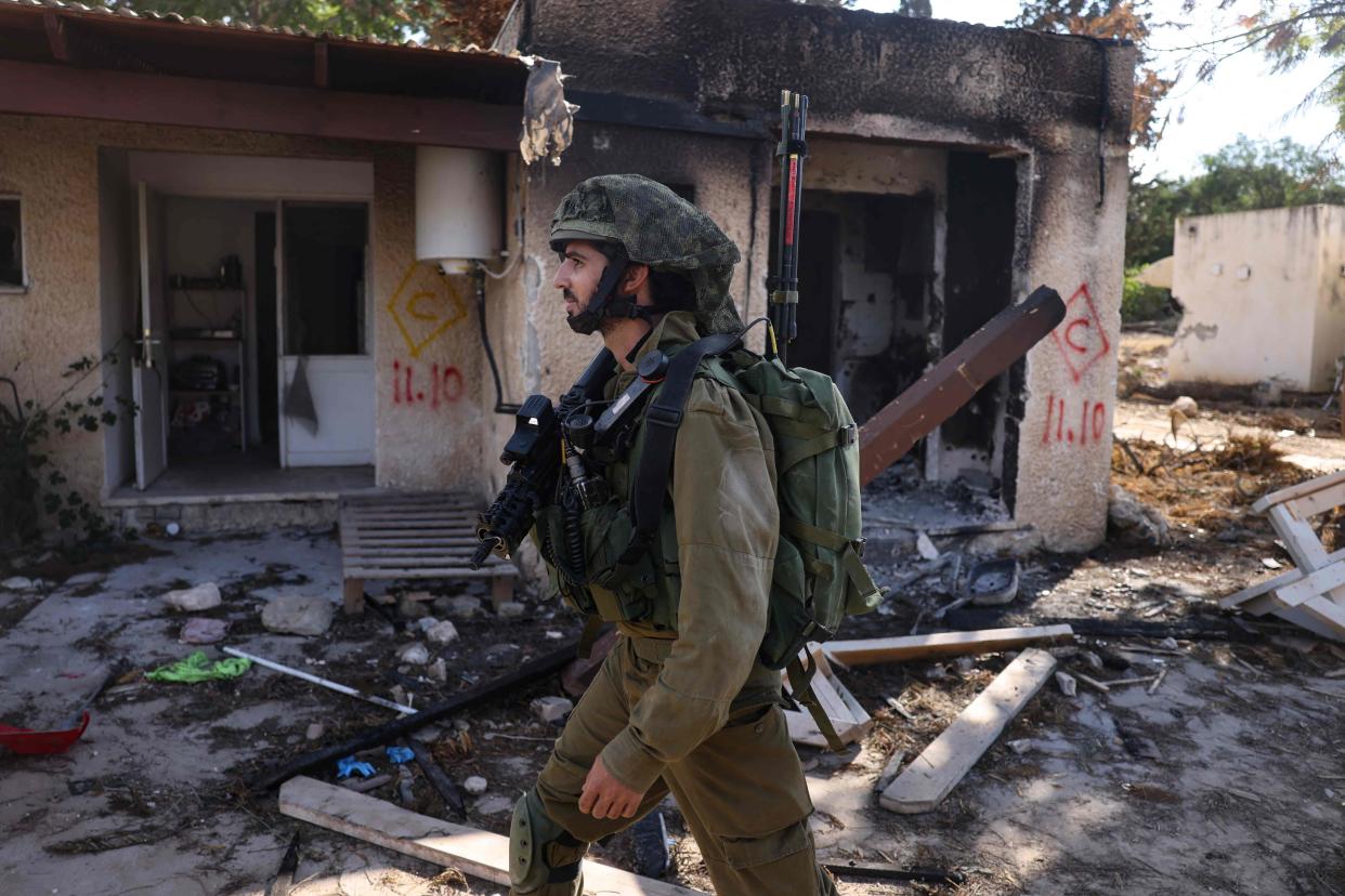 An Israeli soldier patrols inside kibbutz Kfar Aza on the border with the Gaza Strip on Oct. 15, where at least 100 people were reported killed by Hamas militants the previous week.