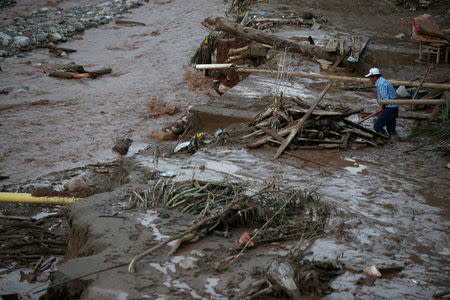 A man searches for his belongings after heavy rains caused several rivers to overflow, pushing sediment and rocks into buildings and roads in Mocoa, Colombia, April 1, 2017. REUTERS/Jaime Saldarriaga