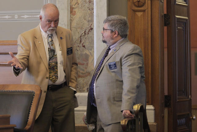 Kansas state Reps. Michael Murphy, left, R-Sylvia, and Kyle Hoffman, right, R-Coldwater, confer during a House debate on overriding Democratic Gov. Laura Kelly's veto of a transgender bathroom bill, Thursday, April 27, 2023, at the Statehouse in Topeka, Kan. Both western Kansas lawmakers supported the measure enacted over Kelly's veto, which may be the most sweeping bathroom law in the U.S. (AP Photo/John Hanna)