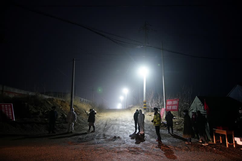 Security members keep watch at an entrance to the Hushan gold mine, where workers are trapped underground after the January 10 explosion, in Qixia