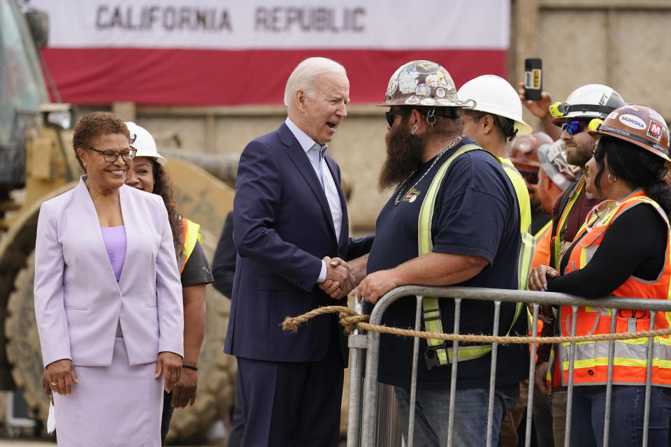 President Joe Biden greets workers as he arrives to speak about infrastructure investments at the LA Metro, D Line (Purple) Extension Transit Project - Section 3, in Los Angeles, Thursday, Oct. 13, 2022. Rep. Karen Bass, D-Calif., looks on at left. (AP Photo/Carolyn Kaster)