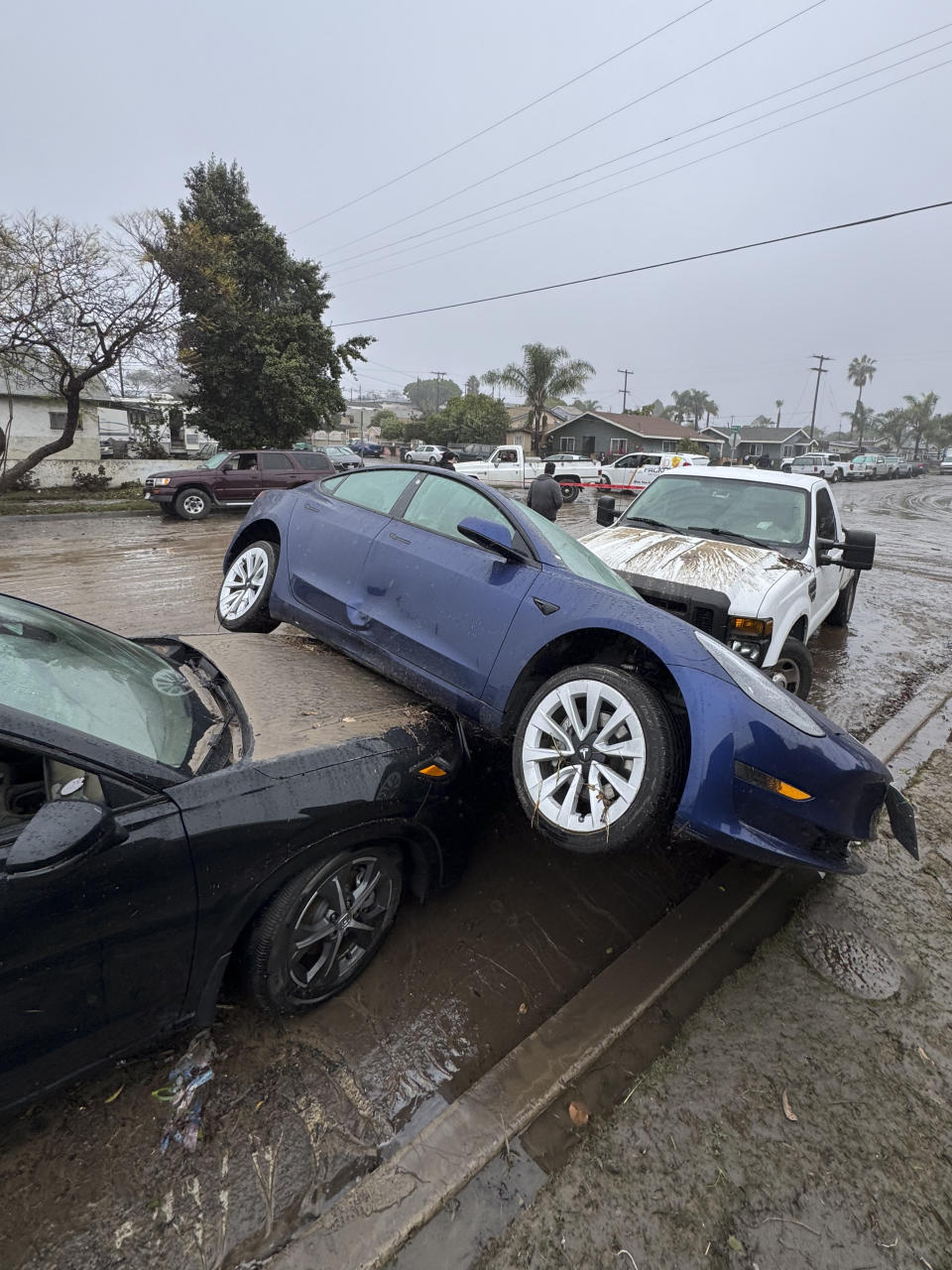 Cars sit damaged from floods during a rain storm Monday, Jan. 22, 2024, in San Diego. (AP Photo/Denis Poroy)
