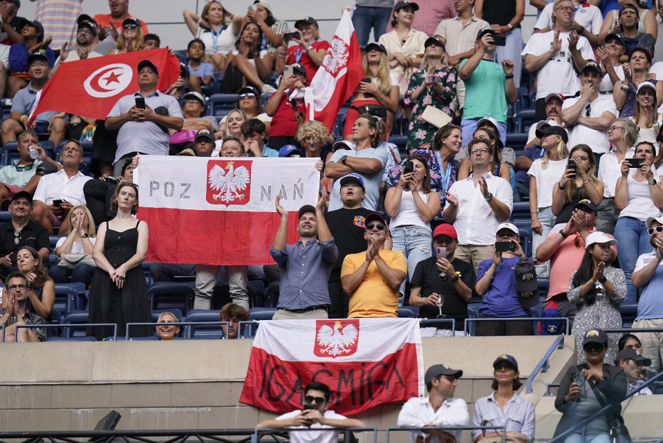 Fans wave the Polish and Tunisian flags after Iga Swiatek, of Poland, defeated Ons Jabeur, of Tunisia, the women's singles final of the U.S. Open tennis championships, Saturday, Sept. 10, 2022, in New York. (AP Photo/Charles Krupa)