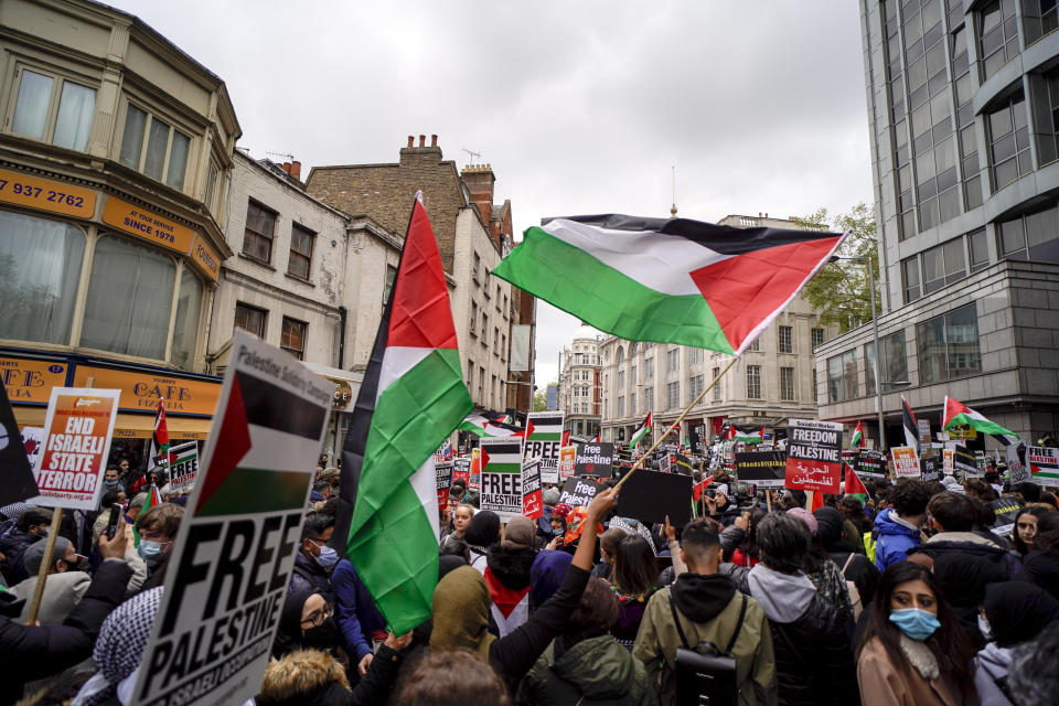 People hold placards and Palestinian flags as they march in solidarity with the Palestinian people amid the ongoing conflict with Israel, during a demonstration in London, Saturday, May 15, 2021. (AP Photo/Alberto Pezzali)