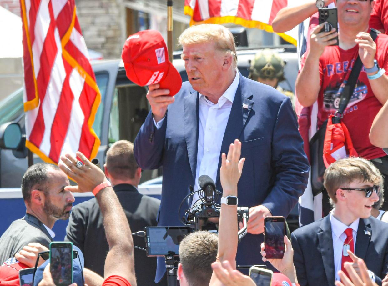 Former U.S. President Donald J. Trump tip his cap near spectators after speaking during a campaign stop on Main Street in downtown Pickens, S.C. last July.