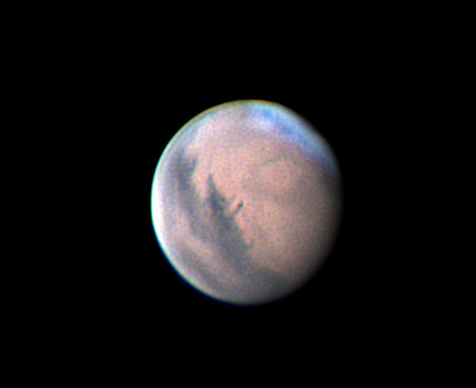Mars was showing some dark surface markings and white haze over its north polar region in this photograph made through the author's 14-inch telescope on the night of November 5. The red planet is moving toward a close swing by Earth in early December. Around that date, some surface features on Mars can be seen with small telescopes.