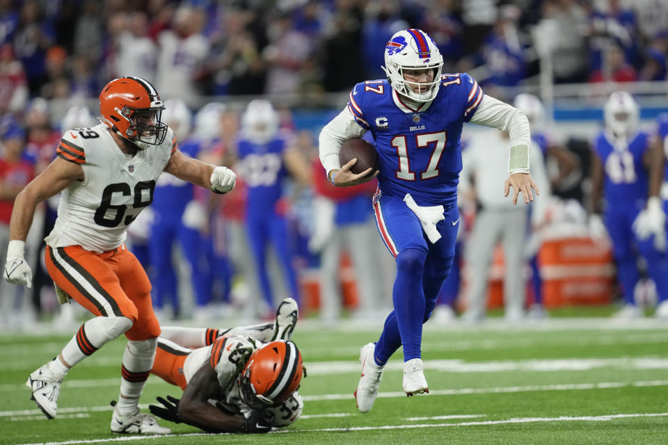 Buffalo Bills quarterback Josh Allen (17) scrambles past Cleveland Browns defensive end Chase Winovich (69) and safety Ronnie Harrison Jr. (33) during the second half of an NFL football game, Sunday, Nov. 20, 2022, in Detroit. (AP Photo/Paul Sancya)