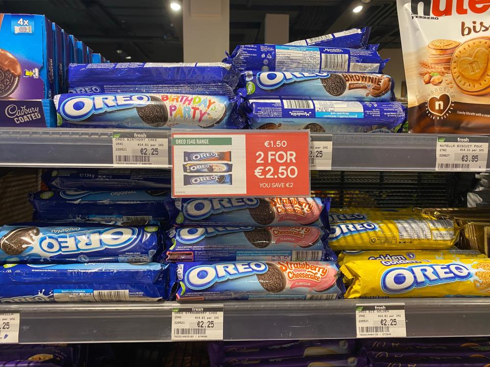 rolls of different flavors of oreos on the shelves of an irish grocery store