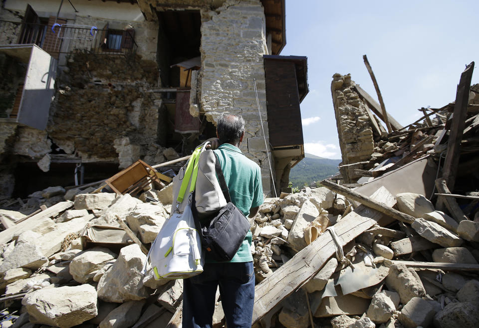 <p>A man stands in front of his collapsed house after recovering his personal belongings, in Villa San Lorenzo, near Amatrice, central Italy, Aug. 27, 2016 where a 6.1 earthquake struck just after 3:30 a.m., Wednesday. (AP Photo/Antonio Calanni) </p>