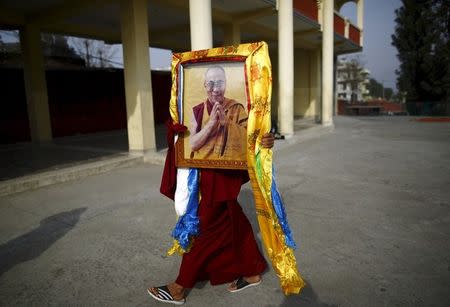 A Tibetan monk carries a portrait of exiled Tibetan spiritual leader, the Dalai Lama, during a function organised to mark "Losar" or the Tibetan New Year, in Kathmandu in this March 4, 2014 file photo. REUTERS/Navesh Chitrakar/Files