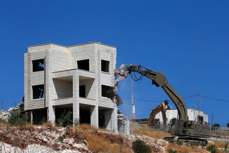 Israeli machinery demolishes a Palestinian house in the village of Sur Baher which sits on either side of the Israeli barrier in East Jerusalem and the Israeli-occupied West Bank