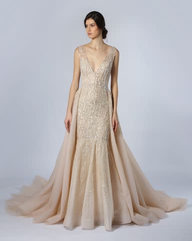 <p>Courtesy of Kleinfeld Bridal</p> A model poses in one of Tony Ward's off-white dresses