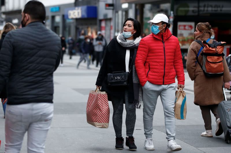 People wearing protective masks walk on a street, following the government's restrictions imposed to contain the spread of coronavirus disease (COVID-19) in Brussels