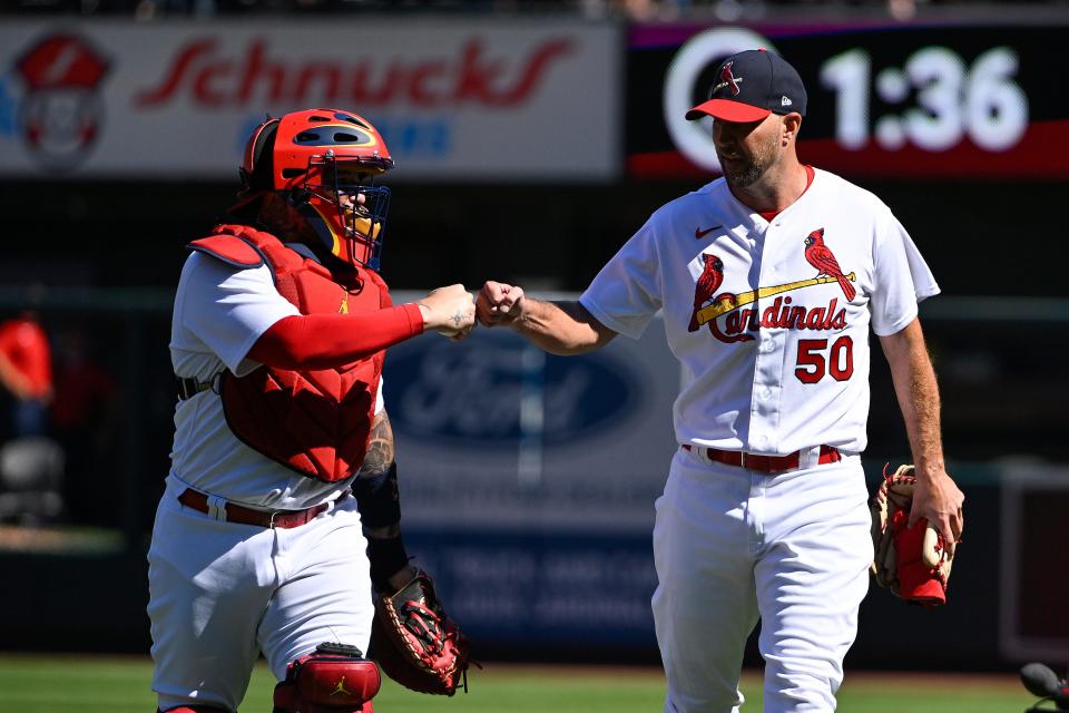 The Cardinals' Adam Wainwright bumps fists with Yadier Molina during their record-breaking 328th start together as pitcher and catcher on October 2. Molina has already announced his retirement, but Wainwright will be back in 2023.