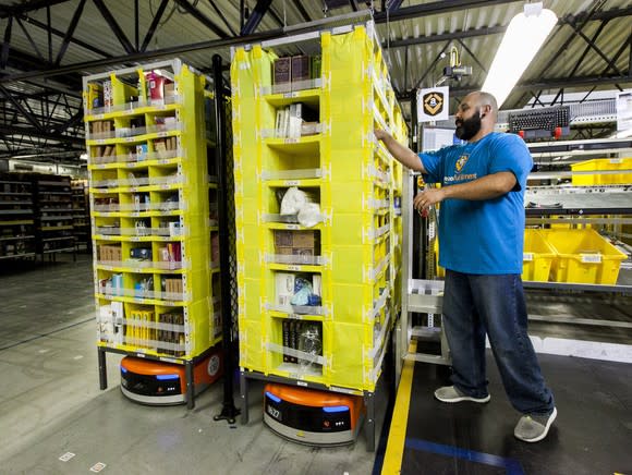 Amazon worker picking items in a fulfillment center.