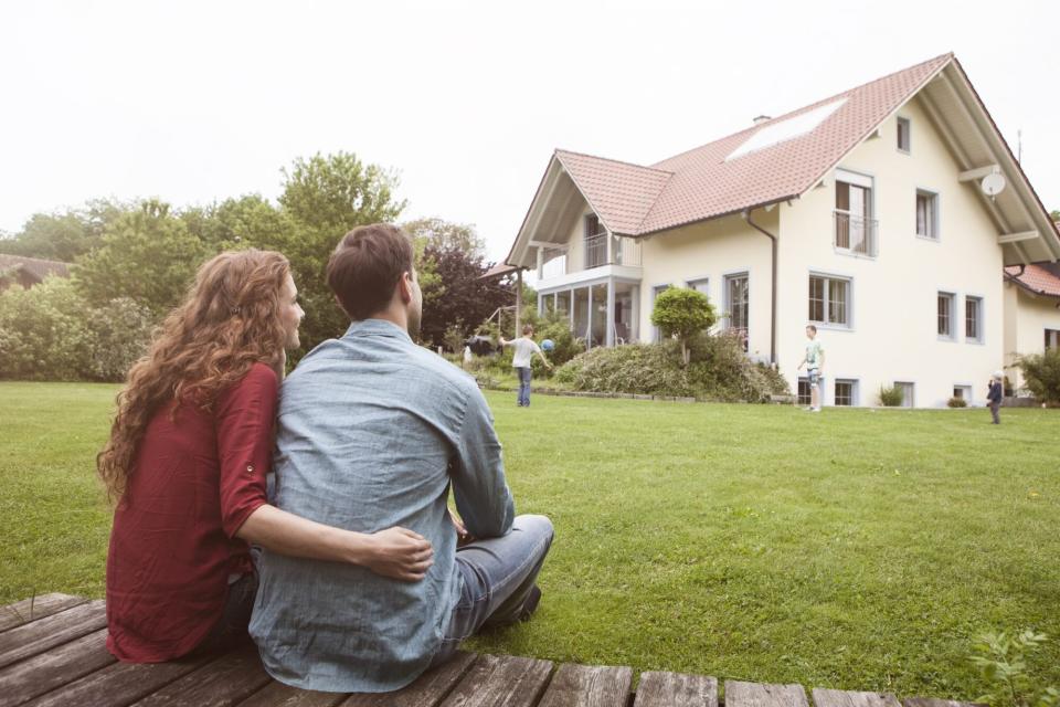 Couple sitting in garden looking at their house