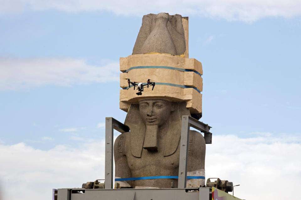 FILE - In this Jan. 25, 2018 file photo, a drone flies around a giant statue of the pharaoh Ramses II as it is relocated to the Grand Egyptian Museum, in Cairo, Egypt. Thousands of Egyptians are laboring in the shadow of the pyramids to erect a monument worthy of the pharaohs. The Grand Egyptian Museum has been under construction for well over a decade and is intended to show off Egypt’s ancient treasures while attracting tourists to help fund its future development. (AP Photo/Amr Nabil, File)