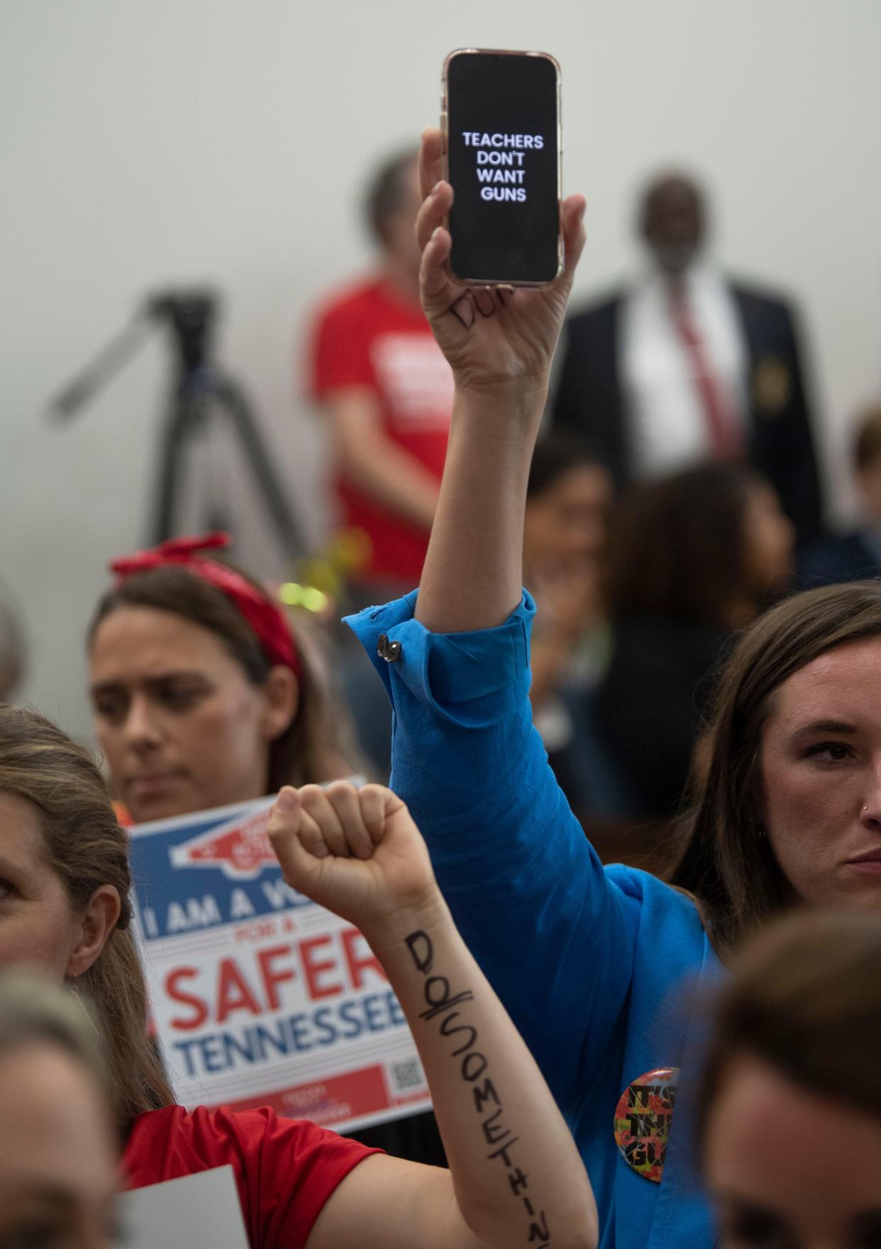 After the House restricted the use of signs, supporters of gun safety reform put messages on their phones and even their hands and arms Aug. 23 in Nashville.