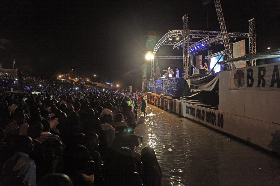 In this photo taken early Sunday, Feb. 9, 2014, Malian singer Salif Keita, rear center, performs on stage at a music festival at Segou, Mali. Long before Mali captured the global spotlight as an al-Qaida training ground where French soldiers had to intervene, the West African nation was celebrated for producing some of the biggest stars in world music. (AP Photo/Baba Ahmed)