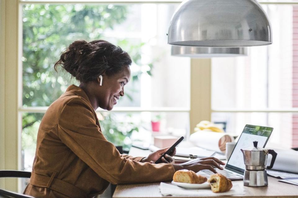 woman smiling working from home wearing earbuds