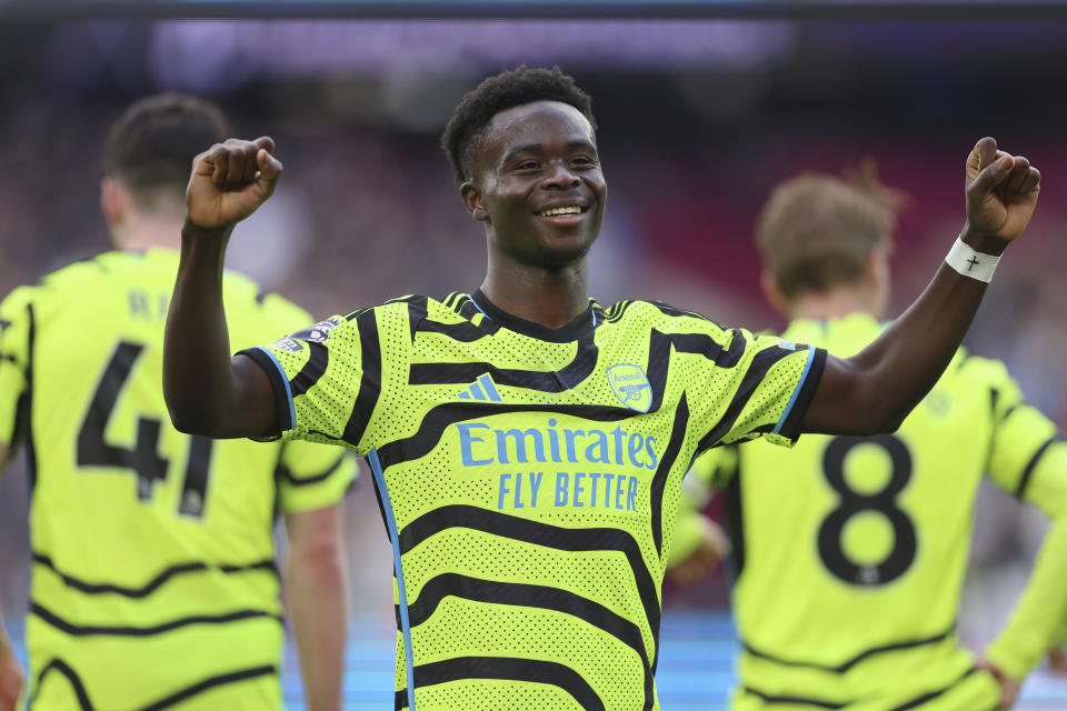 Arsenal's Bukayo Saka celebrates after scoring his sides 5th goal of the game during the English Premier League soccer match between West Ham United and Arsenal at the London Stadium in London, Sunday, Feb. 11, 2024. (AP Photo/Ian Walton)