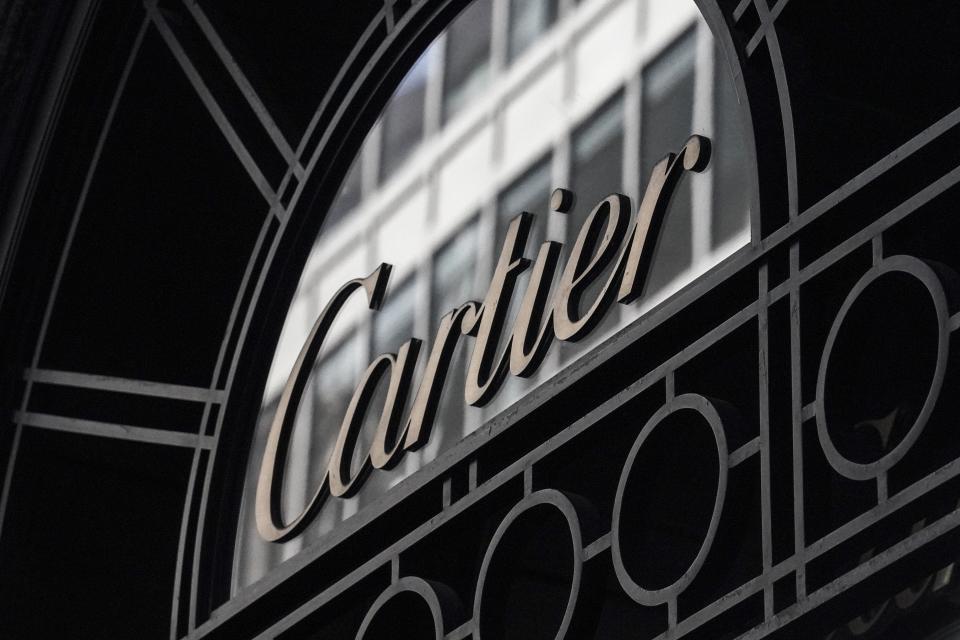 A Cartier sign hangs on the side entrance to its 5th Avenue building, Monday, Feb. 27, 2023, in New York. Cartier took an image down from its website that showed Indigenous children playing in a field of tall, green grass. The French luxury jewelry brand said it was working to promote the culture of the Indigenous people and protect the rainforest. (AP Photo/Bebeto Matthews)