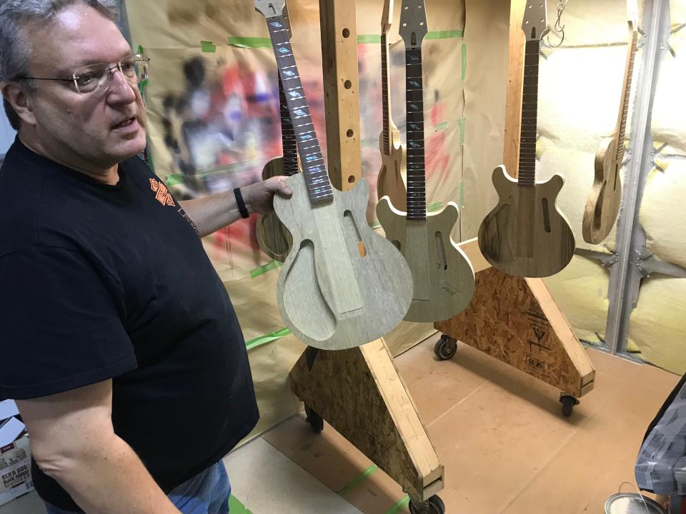 Jim Jaros with a guitar cutout at his Jaros Custom Guitars shop.