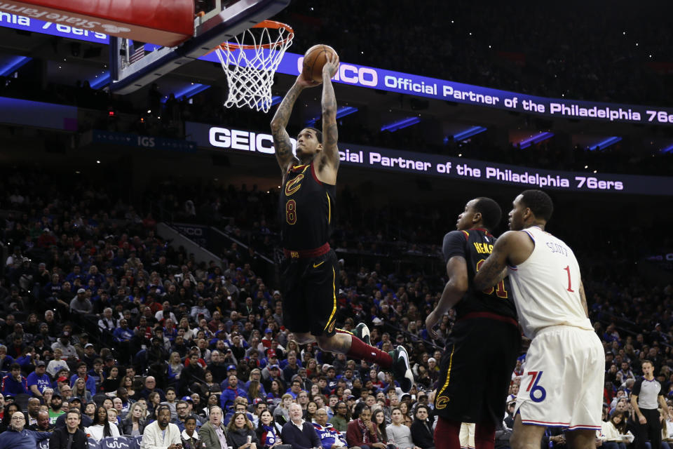 Cleveland Cavaliers' Jordan Clarkson (8) goes up for a dunk as Philadelphia 76ers' Mike Scott (1) and Cavaliers' John Henson (31) look on during the second half of an NBA basketball game, Saturday, Dec. 7, 2019, in Philadelphia. (AP Photo/Matt Slocum)