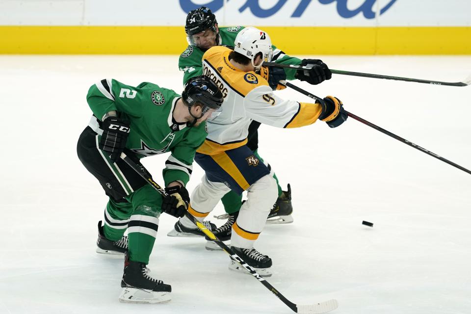 Dallas Stars defenseman Jamie Oleksiak (2) and right wing Denis Gurianov (34) combine to strip the puck away from Nashville Predators forward Filip Forsberg during the first period of an NHL hockey game in Dallas, Friday, Jan. 22, 2021. (AP Photo/Tony Gutierrez)