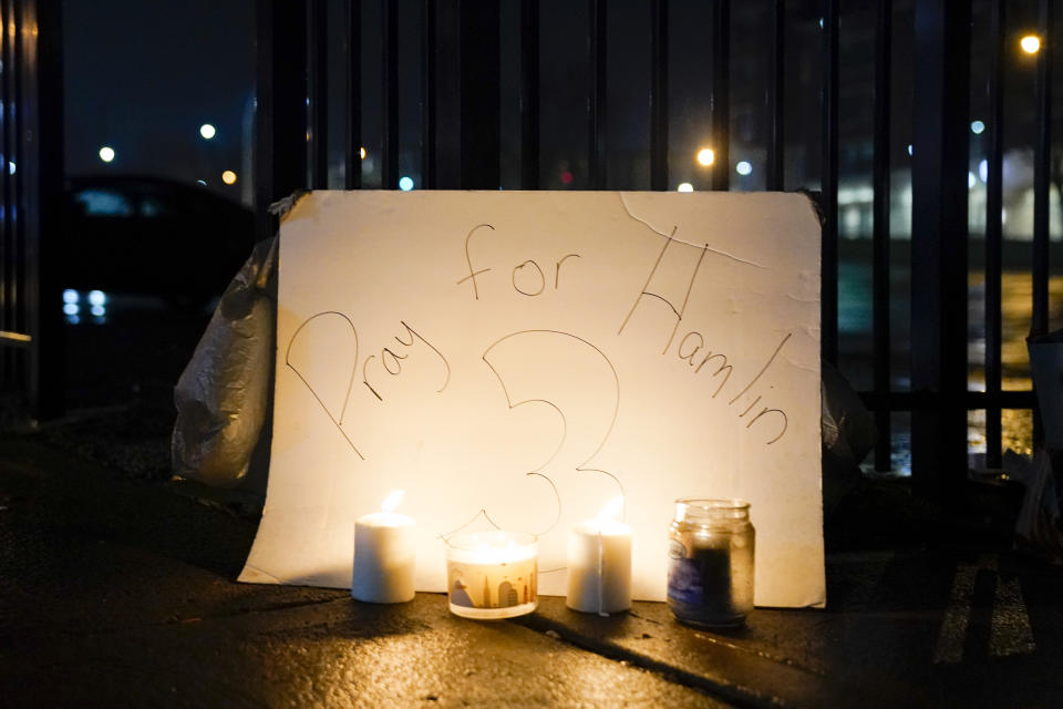 Fans place a sign and candles outside the University of Cincinnati Medical Center, early Tuesday, Jan. 3, 2023, in Cincinnati, where Buffalo Bills' Damar Hamlin was taken after collapsing on the field during an NFL football game against the Cincinnati Bengals on Monday night. (AP Photo/Jeff Dean)