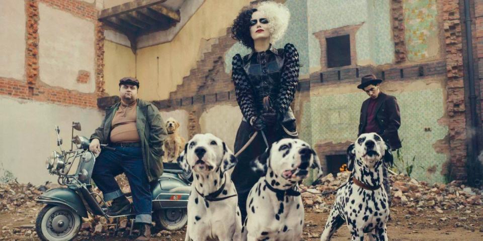 Cruella holds dog leashes