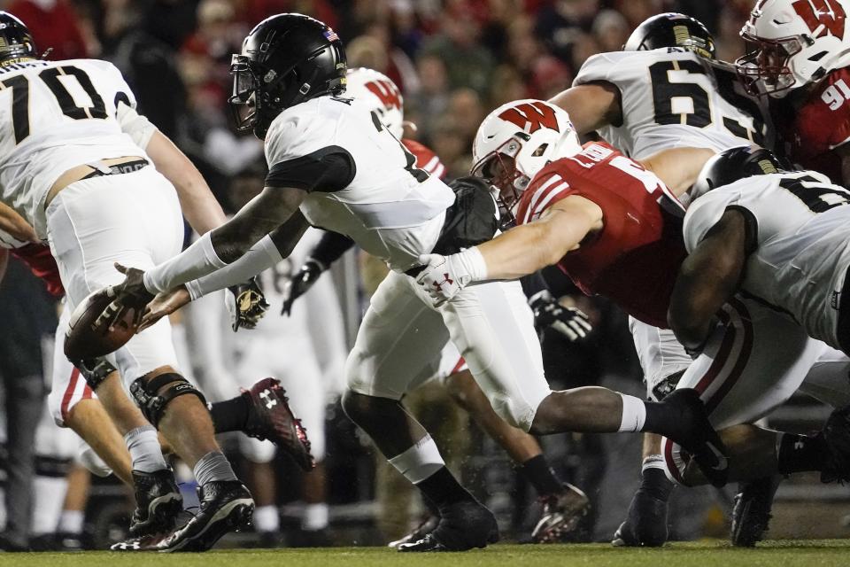 Wisconsin's Leo Chenal hits Army's Tyhier Tyler as he pitches the ball during the first half of an NCAA college football game Saturday, Oct. 16, 2021, in Madison, Wis. (AP Photo/Morry Gash)